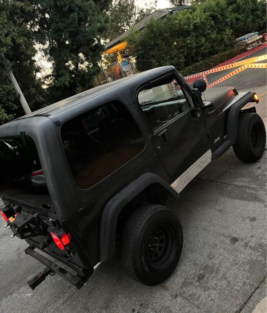 Rear view of Jeep Wrangler TJ with soft top and diamond plate rockers – 1997-2006